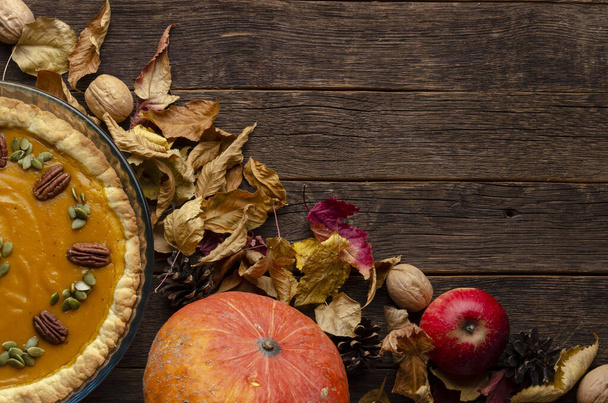 torta de abóbora caseira, sementes de abóbora e folhas de outono em um fundo de madeira
 - Foto, Imagem