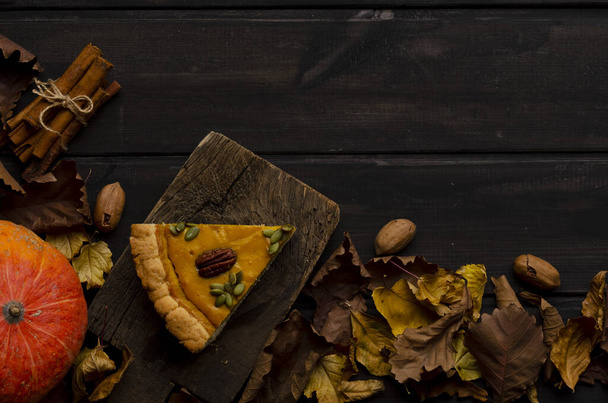 slice of homemade pumpkin pie on dark wooden background. Autumn composition. - Foto, Imagen