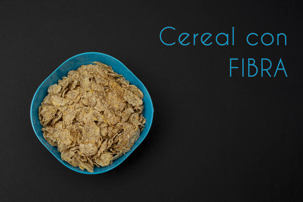 Cereal de fibra en bowl azul sobre fondo negro - 写真・画像