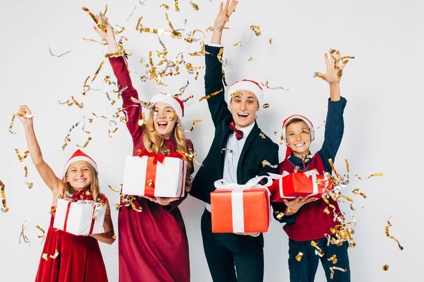 Young happy Christmas family with kids wearing Santa hats having - Фото, изображение