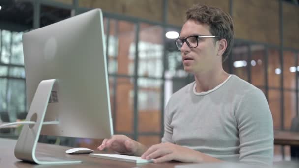schöner Kerl, der sich aufregt, während er am Computer arbeitet - Filmmaterial, Video