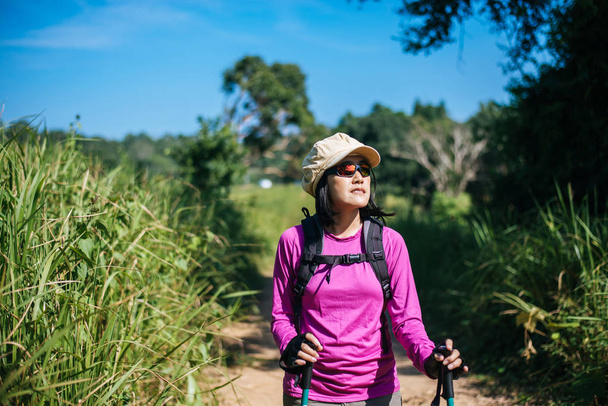 Backpacking Asian woman standing while looking something in the morning at outdoor,Happy and smiling,Camping hiking concept - Fotografie, Obrázek