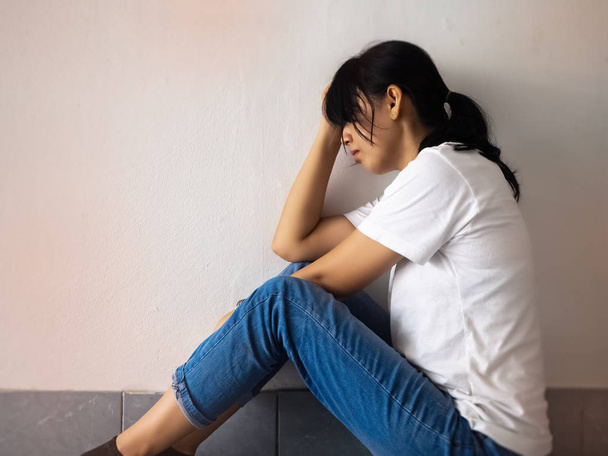 La mujer estresada sentada en la planta baja, tristeza y malestar
 - Foto, Imagen