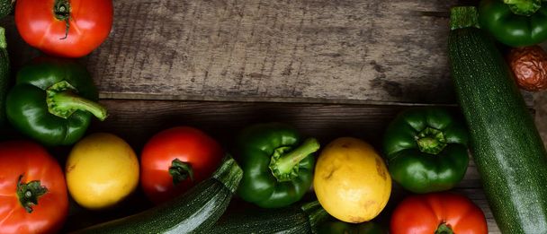 Cucumbers, tomatoes and sweet pepper on wooden table for background - Photo, Image