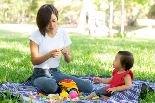 Kaunis nuori aasialainen äiti ja tytär pelaa lelu lohkojen le
 - Valokuva, kuva