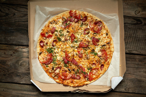 piza redonda assada com salsichas defumadas, cogumelos, tomate, che
 - Foto, Imagem