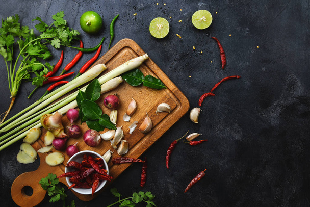 Sebzeler, kesme tahtasındaki sağlıklı gıda otları ve baharatlar. Pişirme hazırlıklarının ham maddeleri Tom Yum. - Fotoğraf, Görsel