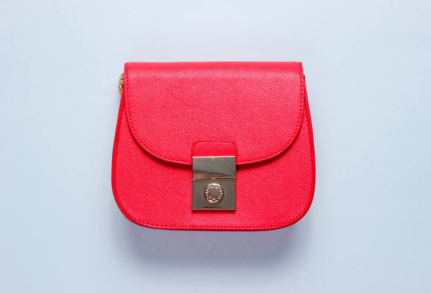 Mini bolso de cuero rojo sobre fondo azul. Concepto de moda minimalista. Vista superior
 - Foto, imagen