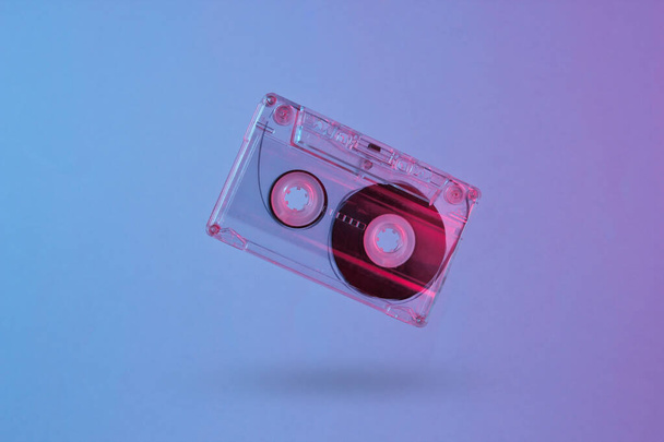 Minimalism retro style concept. 80s. Audio cassette in neon red blue light. Retro wave - Fotoğraf, Görsel