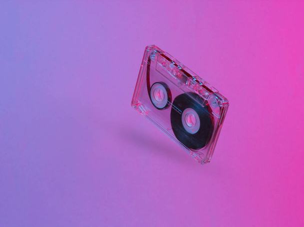 Minimalism retro style concept. 80s. Audio cassette in neon red blue light. Retro wave - 写真・画像