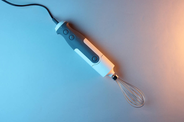 elektrischer Stabmixer mit Schneebesen-Düse im Neonlicht-Hintergrund - Foto, Bild
