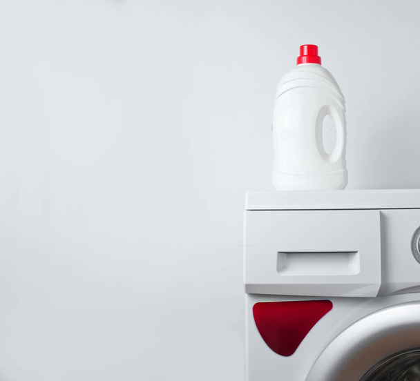 Bottle of washing gel on a washing machine. White background for copy space - Foto, imagen