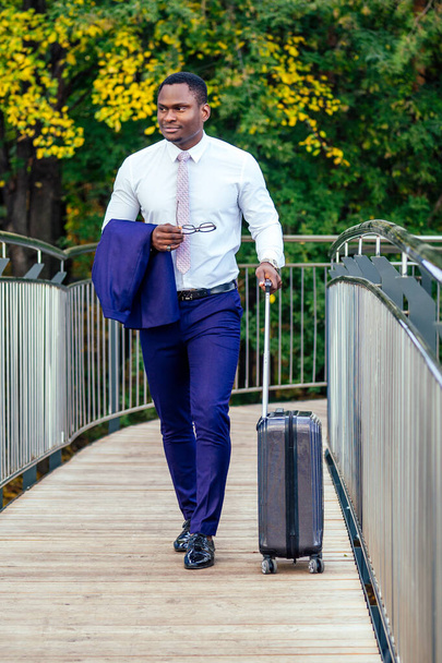 Hombre afroamericano bien vestido y exitoso empresario africano caminando tren en la estación de autobuses de la estación de tren. un viaje a una reunión de negocios en la capital a socios comerciales
 - Foto, Imagen