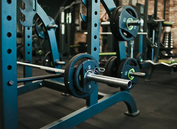 Gym equipment. Dark Gym with barbells on rack. Fitness workout center. Sport concept. - Photo, Image