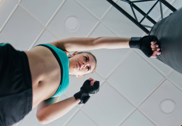 Pohja näkymä naisten nyrkkeilijä koulutusta booli nyrkkeilysäkki. Urheilu nainen
  - Valokuva, kuva
