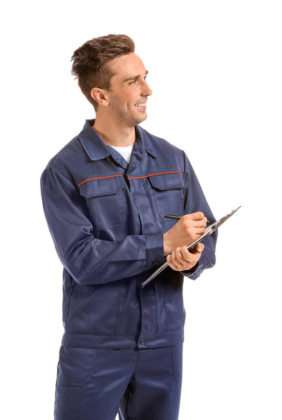 Male car mechanic with clipboard on white background - Фото, изображение