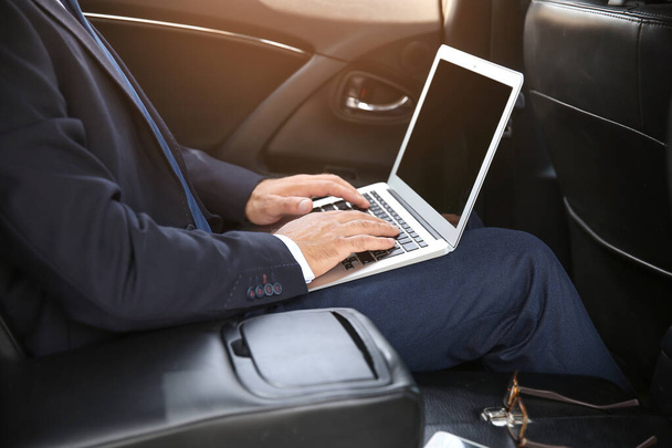 Erfolgreicher Geschäftsmann mit Laptop im modernen Auto - Foto, Bild