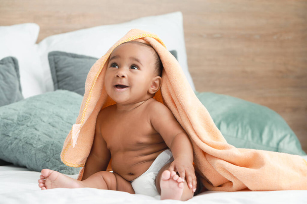 Śliczne African-American Baby z miękkim ręcznikiem na łóżku w domu - Zdjęcie, obraz