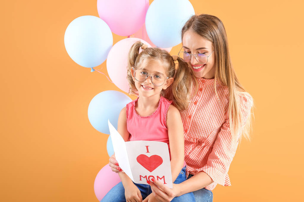 Little girl greeting her mother on color background - Photo, Image