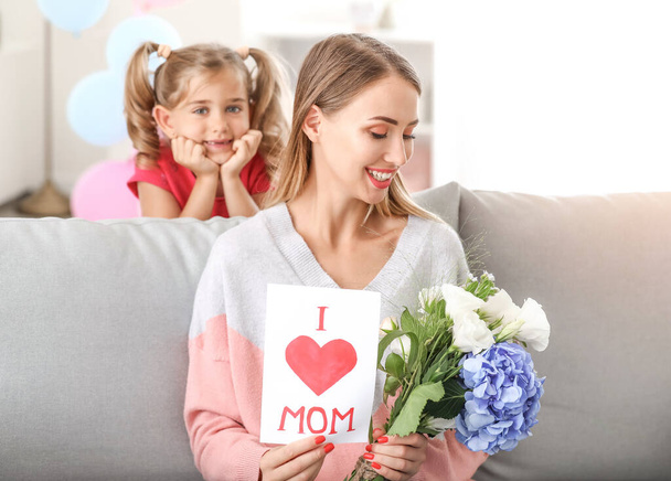 Beautiful young woman with gifts from her daughter at home - Foto, imagen