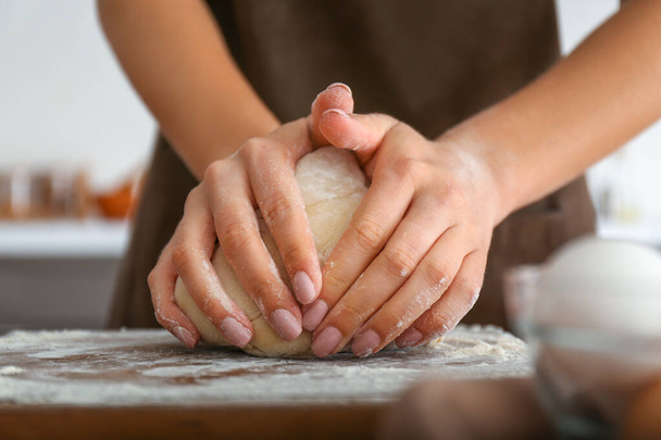 Woman kneading flour in kitchen, closeup - Фото, зображення