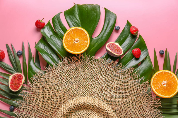 Summer composition with tropical fruits, leaves and hat on color background - Photo, Image