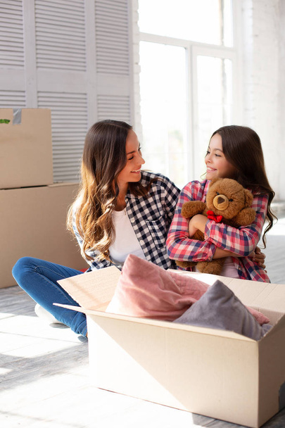 Young mother with daughter in new apartment - 写真・画像