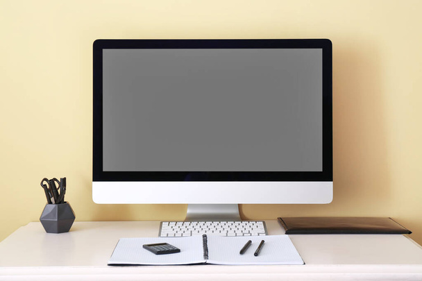 Lugar de trabajo moderno con ordenador cerca de la pared de color - Foto, imagen