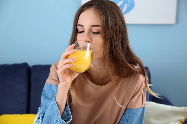Beautiful young woman drinking orange juice at home - Foto, immagini