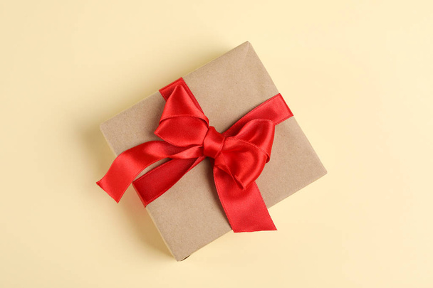 Gift box with bow on color background, space for text - Foto, Imagen