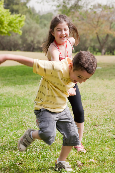 Brother pulling his sister in the park - Photo, Image