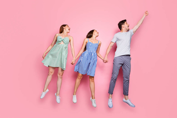 Full size profile side photo of cheerful youth catching umbrella wearing striped t-shirt pants trousers isolated over pink background - Φωτογραφία, εικόνα