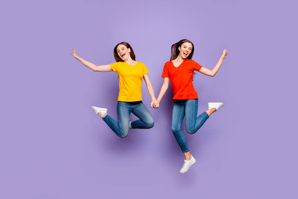 Full body size length photo of two charming beautiful careless fascinating nice optimistic glad ladies flying up in air isolated violet background - Foto, Imagen