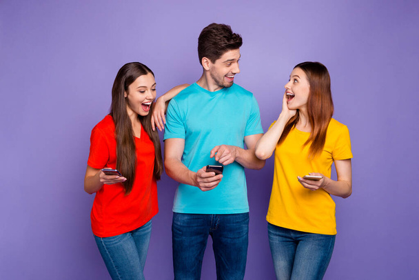 Portré szép vonzó szép vidám vidám boldog srácok visel színes pólók farmer böngészés 5g app híradó játék értesítés szolgáltatás ingyenes idő elszigetelt felett lila orgona háttér - Fotó, kép