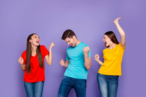 Portrait of nice attractive lovely charming cheerful cheery careless carefree overjoyed guys wearing colorful t-shirts jeans having fun event free time isolated over violet lilac background - Foto, Imagen