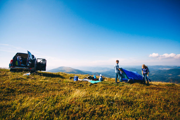 Les jeunes familles préparent la tente En camping Vacances
 - Photo, image