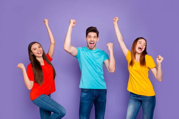 Portrait of nice attractive content cheerful cheery glad overjoyed lucky guys wearing colorful t-shirts jeans denim celebrating cool attainment having fun isolated over violet lilac background - Fotó, kép