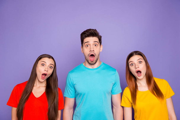 Portrait of nice-looking attractive lovely funny funky afraid guys wearing colorful t-shirts showing astonishment expression stupor isolated over violet lilac background - Фото, изображение