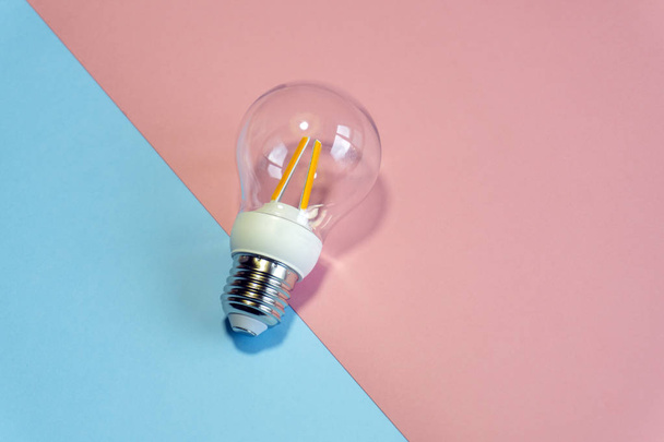 Light bulb ( lightbulb) on a colored background. Minimal concept - Valokuva, kuva