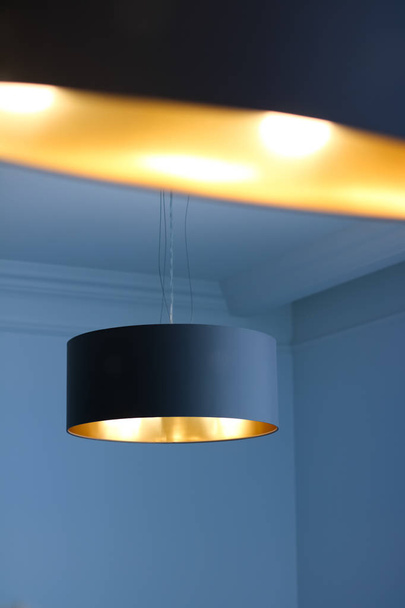 Goldene Lampe im Zimmer, elegante moderne Dekorbeleuchtung - Foto, Bild