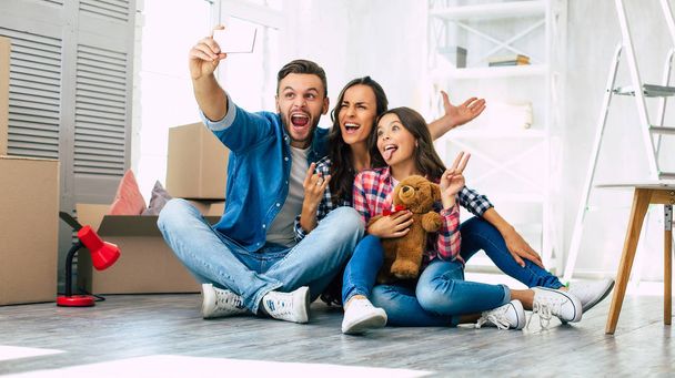 Happy young family in their new apartment - Фото, изображение