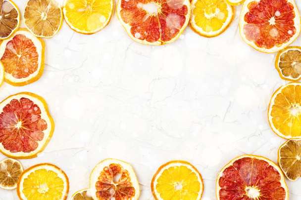Border of Dried slices of various citrus fruits on white background. Orange lemon grapefruit with copyspace - Foto, Imagen