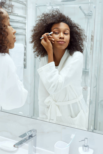 Beauty makeup. Woman applying cosmetics on eyes at bathroom - Foto, Bild