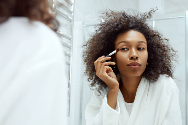 Beauty makeup. Woman applying cosmetics on eyes at bathroom - Fotografie, Obrázek