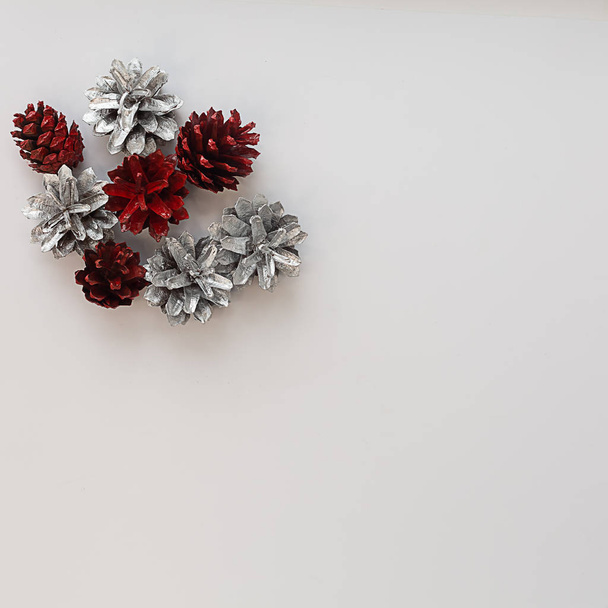 Christmas composition. Silver pine cones on white square backgro - Photo, image