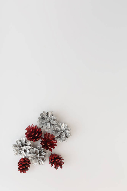 Composição de Natal. Cones de pinho de prata em backg vertical branco
 - Foto, Imagem