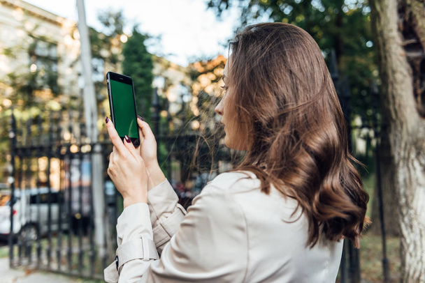 Üzleti nő használ okos telefon a városban működő technológia. - Fotó, kép
