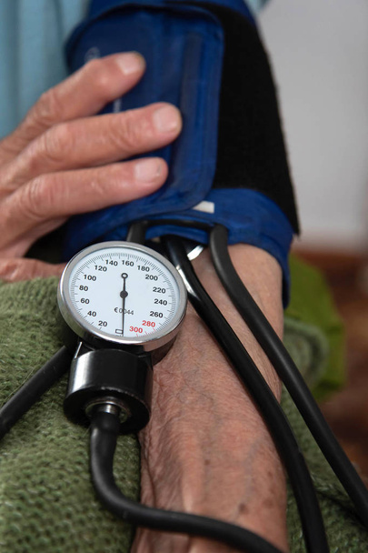 meten van de bloeddruk bij een oudere patiënt - Foto, afbeelding