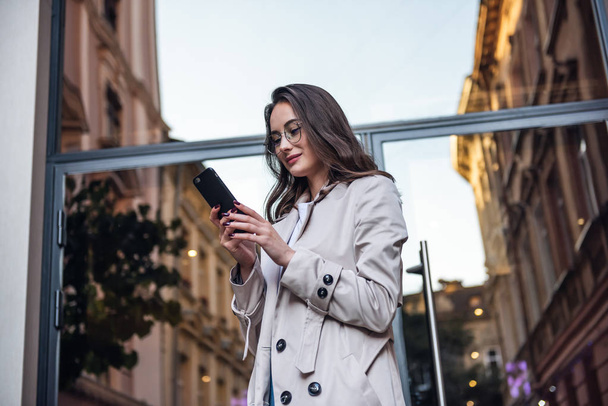 Business woman talking on smart phone. Business people office worker talking on smartphone smiling happy. Young multiracial Asian / Caucasian female professional outside. - 写真・画像