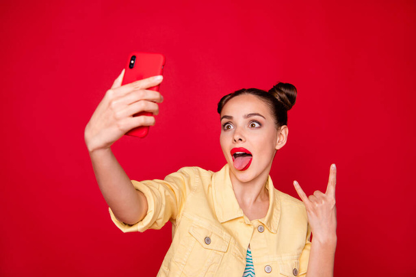 Photo of pretty lady holding telephone hands making selfies on rock concert wear casual outfit isolated red background - Photo, image